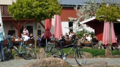 Im Vordergrund Fahrräder, im Hintergrund Blick auf die besetzte Terrasse